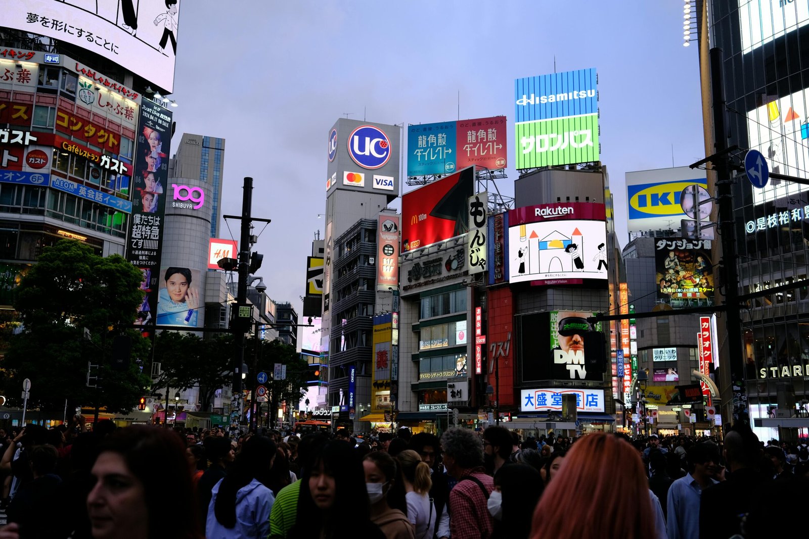 Bustling street scene at Shibuya Crossing, a famous urban landmark in Tokyo, Japan, at night.
