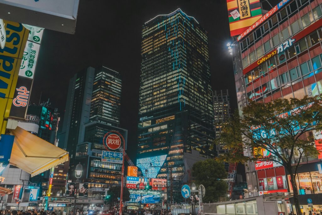 Night scene of Tokyo with illuminated skyscrapers and bustling street life, showcasing vibrant city energy.