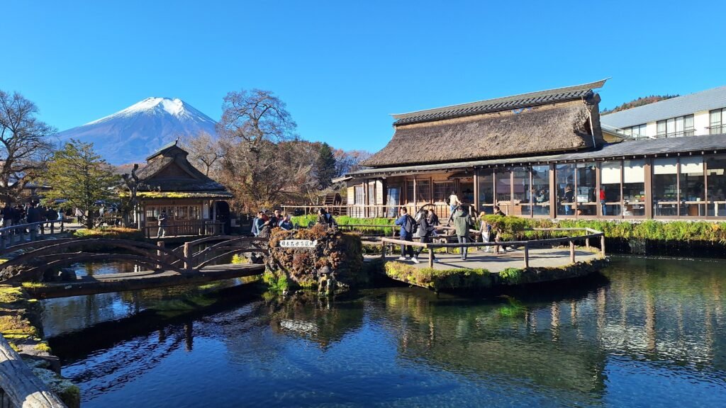 Scenic view of a traditional Japanese village with Mount Fuji in the background.