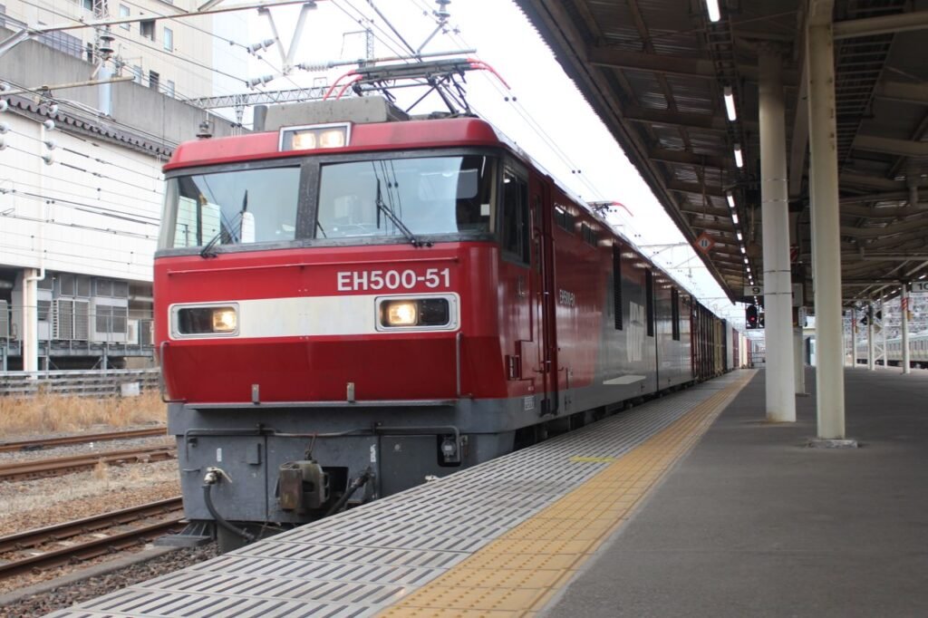 Red locomotive at a Japanese train station platform in Utsunomiya, Tochigi Prefecture, Japan.