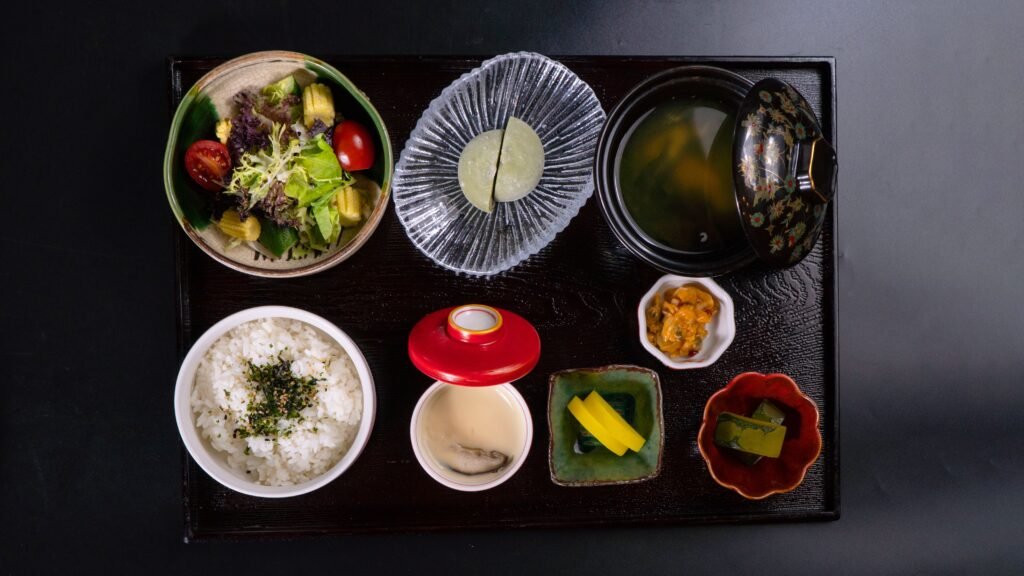 Top view of a traditional Japanese meal with rice, soup, salad, and side dishes on a tray.