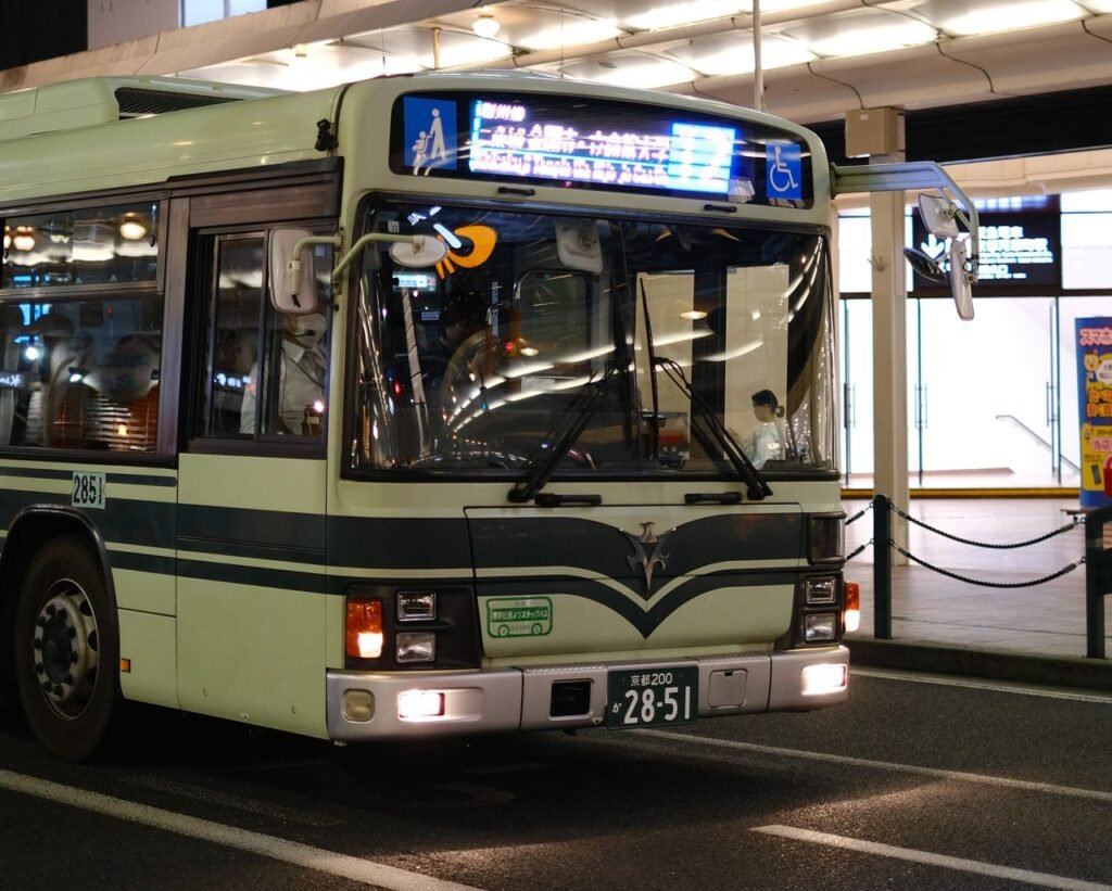 A city bus at night with illuminated signs in an urban environment.