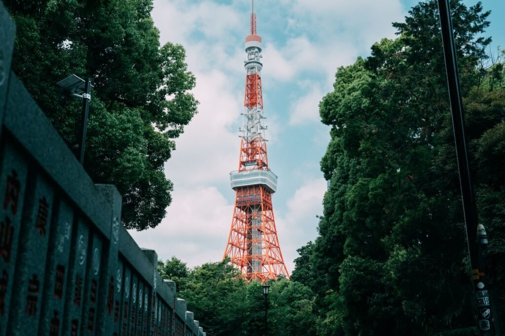 View of the iconic Tokyo Tower surrounded by vibrant greenery on a clear day.