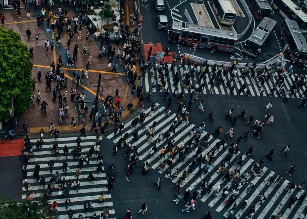 Crowded Shibuya Crossing in Tokyo from above, showcasing urban life and movement.