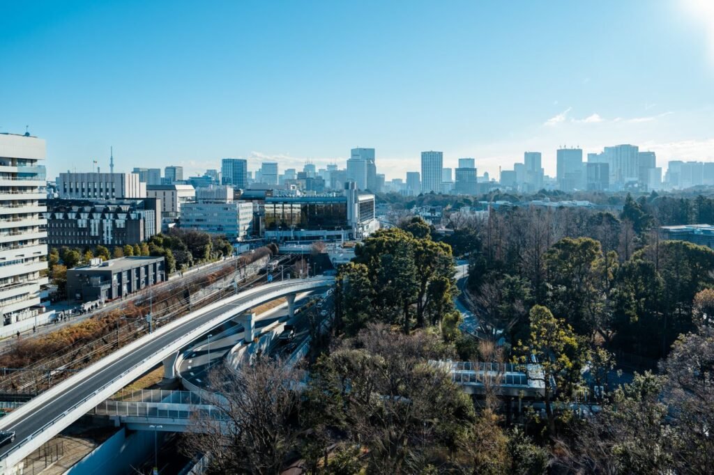 Skyline of Tokyo featuring modern buildings and green urban spaces under a clear blue sky.