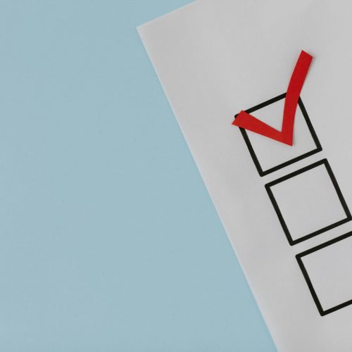 A simple white paper checklist with one red checkmark, ideal for concepts like completion or approval.